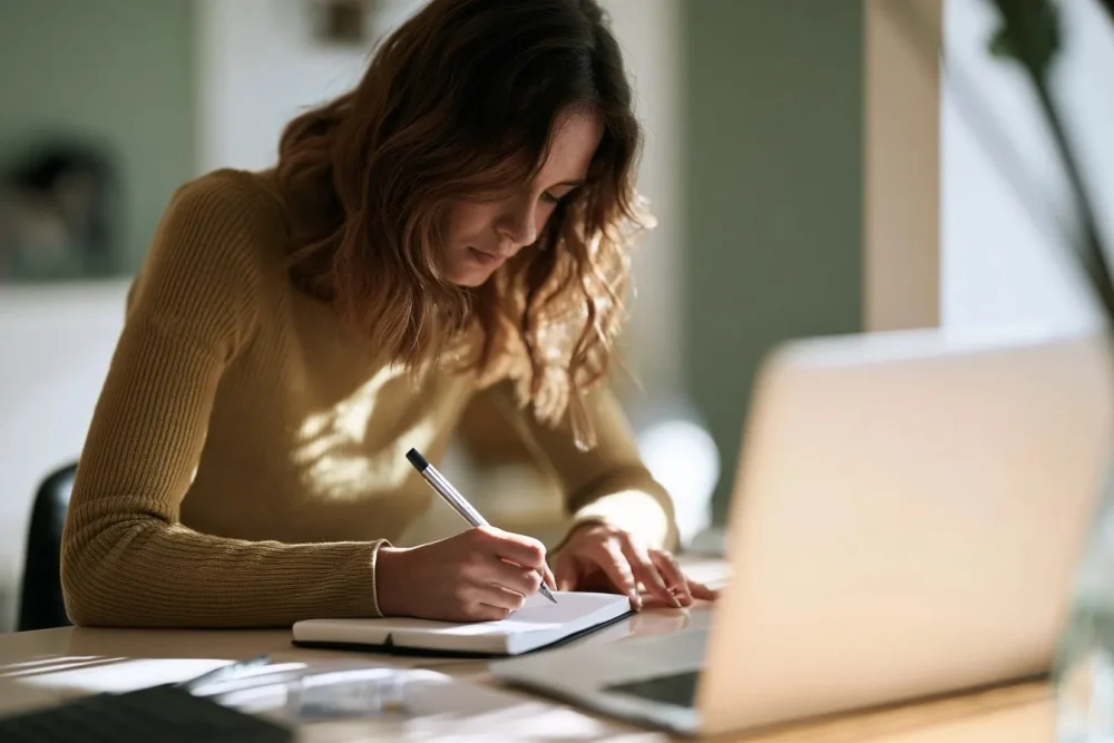 Femme préparant des notes concises devant un ordinateur